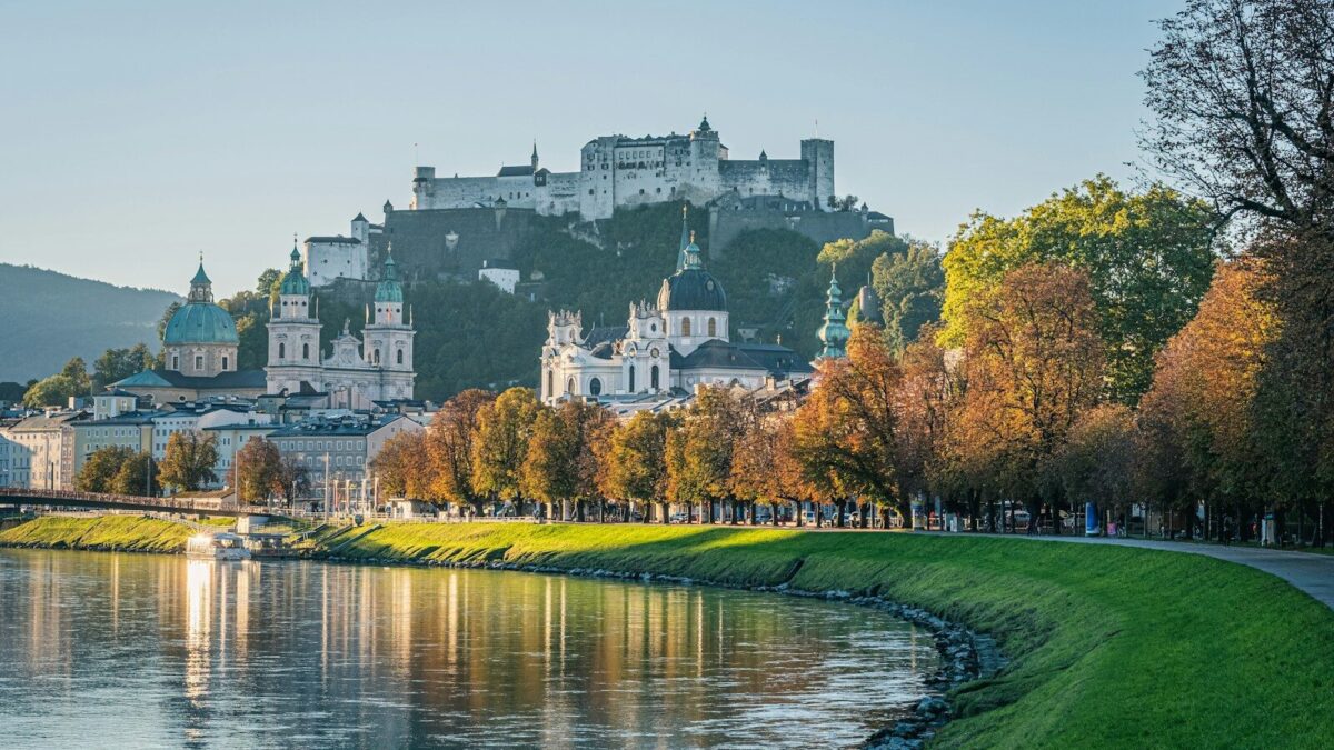 Photo by Free Walking Tour Salzburg white and black concrete building near green grass field and river during daytime