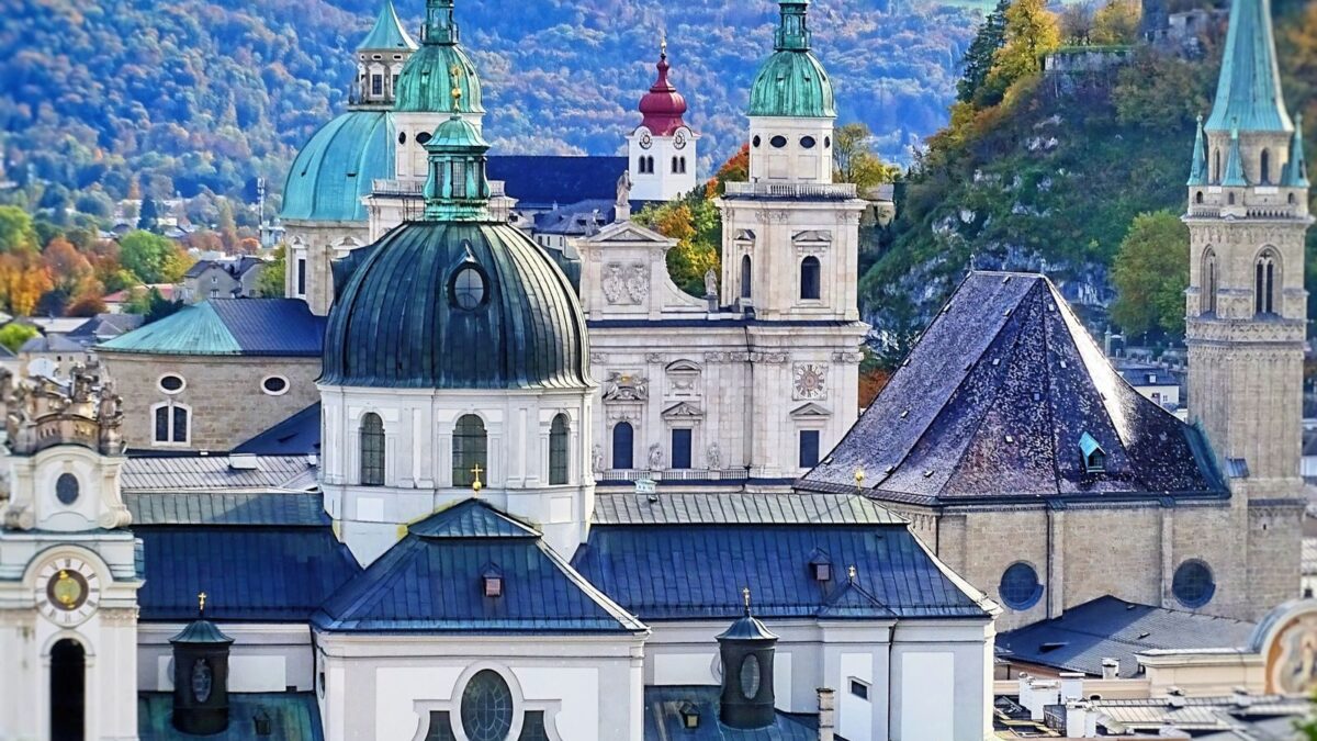 Photo by Zepps Project A picturesque view of Salzburg's iconic cathedrals with mountains in the background, showcasing cultural history.