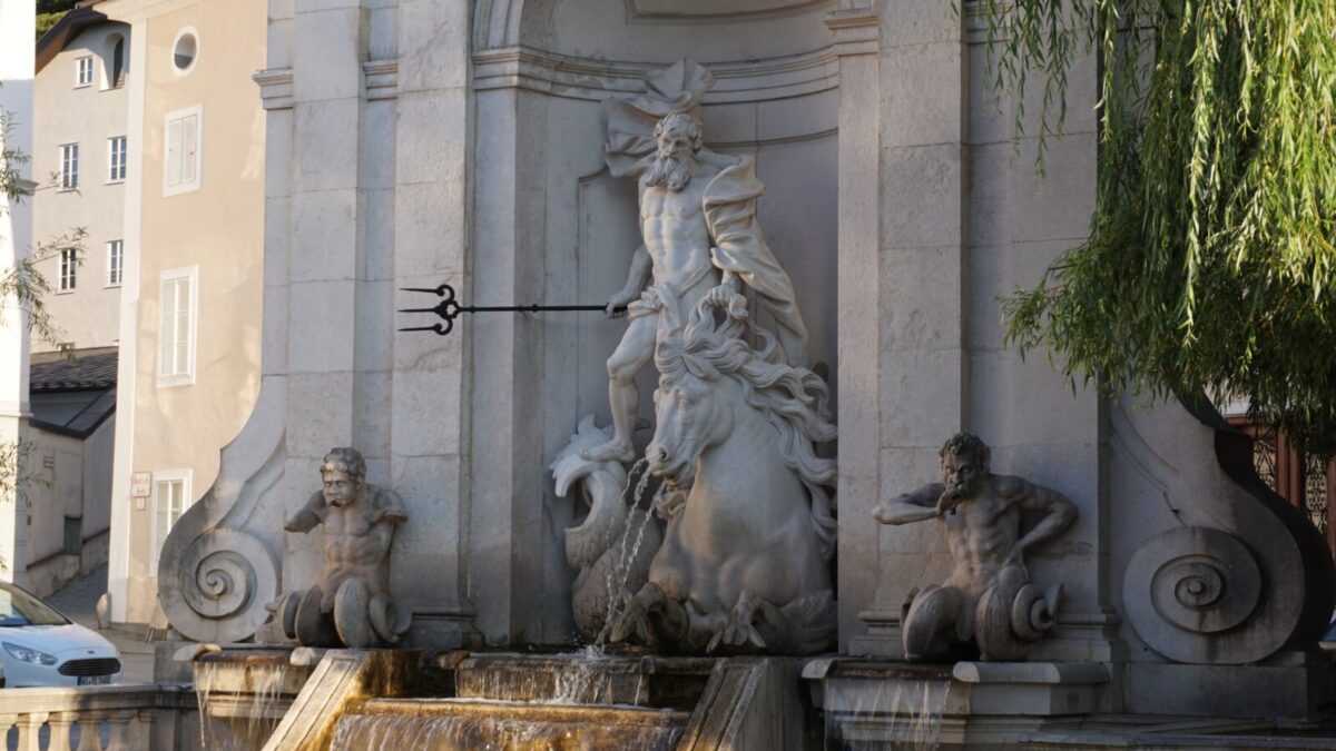 Statues of a fountain in Salzburg showcasing classical architecture and artistic elegance.