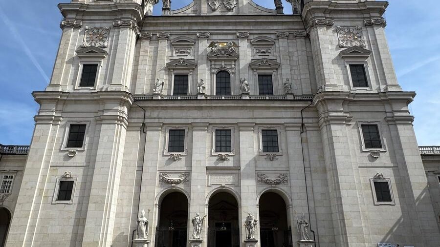 Photo by Taufiq Siddiqui Front view of the grand Salzburg Cathedral under a clear blue sky.