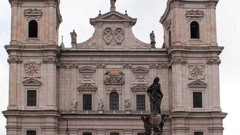 a large stone building with a statue in front of it
