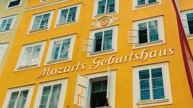 Photo by Reiseuhu a tall yellow building with a clock on the front of it