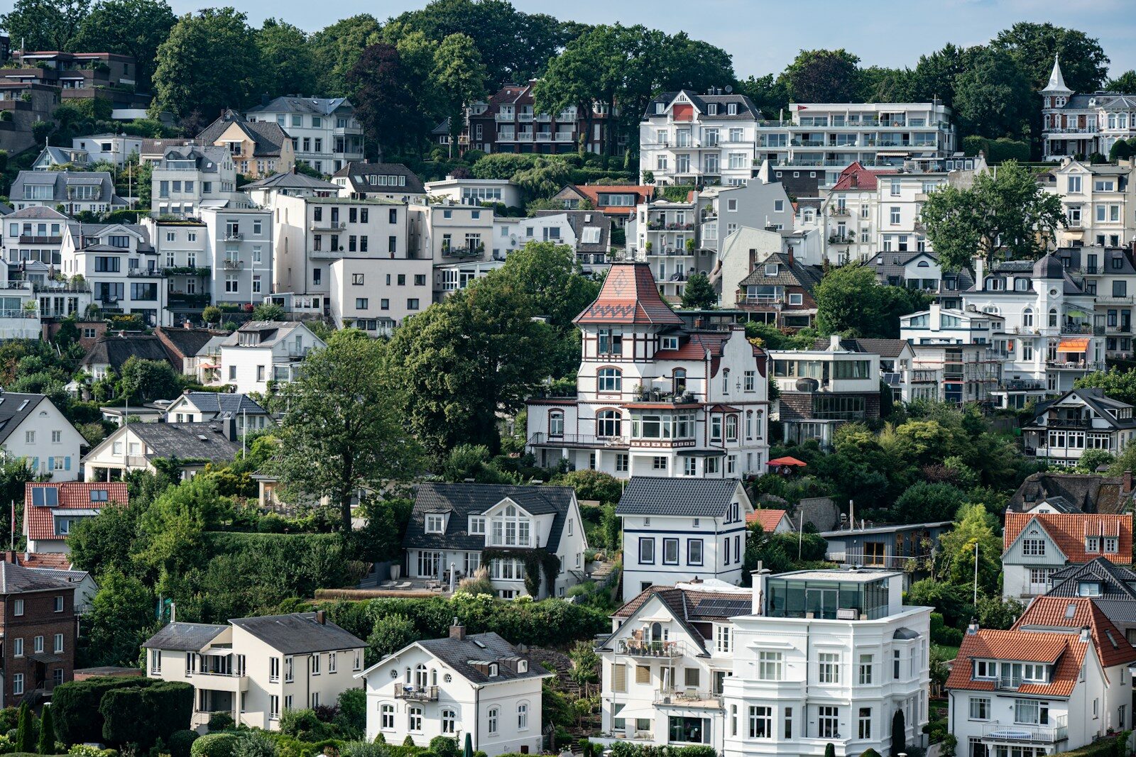 Many houses on a green, hilly landscape